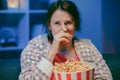 Young woman cry while watching a very moving movie with popcorn at night Royalty Free Stock Photo