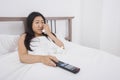 Young woman crying while watching TV in bed Royalty Free Stock Photo