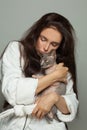 Young woman cuddling sphinx cat