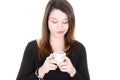 Young woman with cup of coffee looks down mug