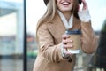 Young woman with cup of coffee on street in morning, focus on hand Royalty Free Stock Photo