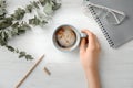 Young woman with cup of delicious hot coffee at table Royalty Free Stock Photo