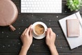 Young woman with cup of delicious hot coffee at table Royalty Free Stock Photo