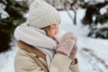 A young woman with a cup of hot tea in mittens. Beautiful winter park. Royalty Free Stock Photo