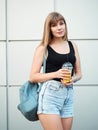 Young woman with cup of tasty lemonade having fun metal geometric background wall