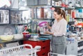 Woman customer choosing ware for wine bottle in tableware shop