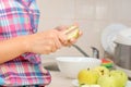 Young woman cuts apple on the kitchen