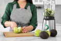 Young woman cutting apple for smoothie at white table in kitchen, closeup Royalty Free Stock Photo