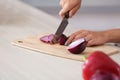 Young woman cutting onion at table Royalty Free Stock Photo