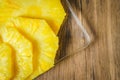 Young Woman cutting a pineapple on a wooden table in the kitchen Royalty Free Stock Photo