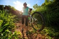 woman cyclist carrying mountain bike climbing on summer forest trail Royalty Free Stock Photo