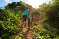 Cyclist carrying mountain bike climbing on summer forest trail Royalty Free Stock Photo