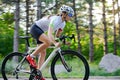 Young Woman Cyclist Riding Road Bicycle on the Free Road in the Forest at Hot Summer Day. Healthy Lifestyle Concept. Royalty Free Stock Photo