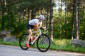 Young Woman Cyclist Riding Road Bicycle on the Free Road in the Forest at Hot Summer Day. Healthy Lifestyle Concept. Royalty Free Stock Photo