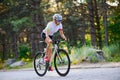 Young Woman Cyclist Riding Road Bicycle on the Free Road in the Forest at Hot Summer Day. Healthy Lifestyle Concept. Royalty Free Stock Photo