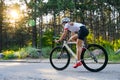 Young Woman Cyclist Riding Road Bicycle on the Free Road in the Forest at Hot Summer Day. Healthy Lifestyle Concept. Royalty Free Stock Photo