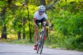 Young Woman Cyclist Riding Road Bicycle on the Free Road in the Forest at Hot Summer Day. Healthy Lifestyle Concept. Royalty Free Stock Photo