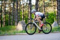 Young Woman Cyclist Riding Road Bicycle on the Free Road in the Forest at Hot Summer Day. Healthy Lifestyle Concept. Royalty Free Stock Photo