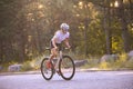 Young Woman Cyclist Riding Road Bicycle on the Free Road in the Forest at Hot Summer Day. Healthy Lifestyle Concept. Royalty Free Stock Photo