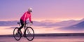 Young Woman Cyclist Riding Road Bike in the Beautiful Mountains at Purple Sunset. Adventure, Healthy Lifestyle, Sport