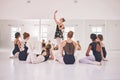 Young woman dance instructor teaching a ballet class to a group of a children in her studio. Ballerina teacher working Royalty Free Stock Photo