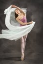 Young woman dancing with green fabric flying in the studio Royalty Free Stock Photo