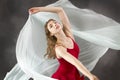 Young woman dancing with green fabric flying in the studio Royalty Free Stock Photo