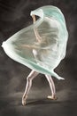 Young woman dancing with green fabric flying in the studio Royalty Free Stock Photo