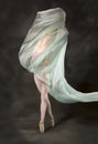 Young woman dancing with green fabric flying in the studio Royalty Free Stock Photo