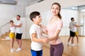 Young woman dancing waltz in pair with tween son during family dance class Royalty Free Stock Photo