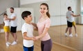 Young woman dancing waltz in pair with tween son during family dance class Royalty Free Stock Photo