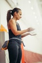 Young woman with chalked hands posing at indoor climbing gym wall