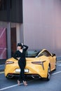 Beautiful brunette woman with yellow sport car Royalty Free Stock Photo
