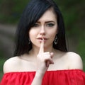 Young woman with dark long hair saying shh with forefinger on lips. silence gesture Royalty Free Stock Photo