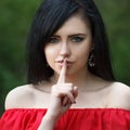 Young woman with dark long hair saying shh with forefinger on lips. silence gesture Royalty Free Stock Photo