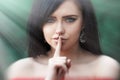 Young woman with dark long hair saying shh with forefinger on lips. silence gesture Royalty Free Stock Photo