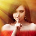 Young woman with dark long hair saying shh with forefinger on lips. silence gesture Royalty Free Stock Photo