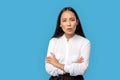 Freestyle. Young woman wearing shirt and skirt standing isolated on blue crossed arms looking camera concerned Royalty Free Stock Photo