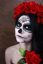 Day of the dead. Halloween. Young woman in day of the dead mask skull face art and rose. Dark background. Royalty Free Stock Photo