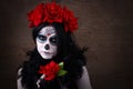 Day of the dead. Halloween. Young woman in day of the dead mask skull face art and rose. Dark background. Royalty Free Stock Photo