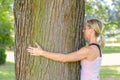 Young woman daydreaming while hugging a tree Royalty Free Stock Photo