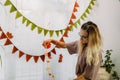 Young woman decorate house for Halloween. Interior of the house decorated for Halloween with DIY ghost balloon and houseplant in