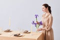 Young Woman Decorating Dining Table with Flowers