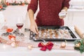 Young woman decorating gingerbread cookies for Christmas