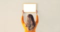 Young woman decorating interior, hanging blank a photo frame mockup on white wall in a new house Royalty Free Stock Photo
