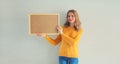 Young woman decorating interior, hanging blank a photo frame mockup on white wall in a new house Royalty Free Stock Photo