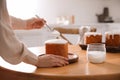 Young woman decorating traditional Easter cake with glaze in kitchen, closeup Royalty Free Stock Photo