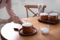 Young woman decorating traditional Easter cake with glaze in kitchen, closeup. Space for text Royalty Free Stock Photo