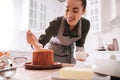 Young woman decorating traditional Easter cake with glaze in kitchen, focus on hand Royalty Free Stock Photo