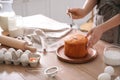 Young woman decorating traditional Easter cake with glaze in kitchen, closeup Royalty Free Stock Photo